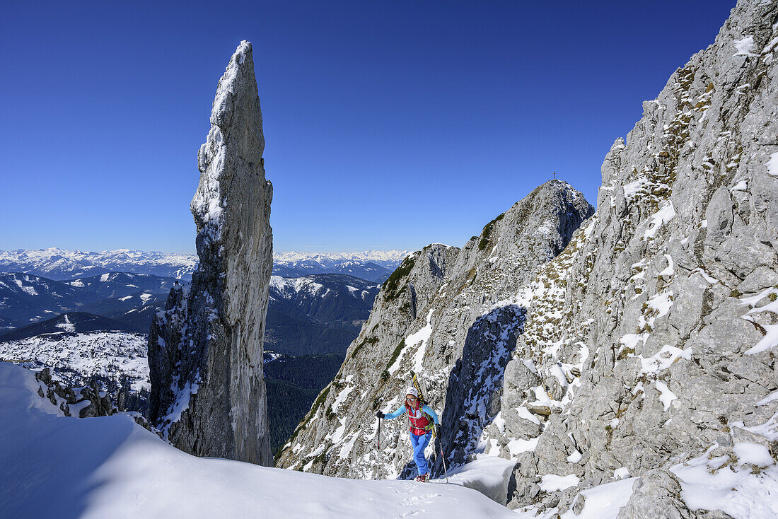 Woman back-country skiing ascending in Angersteinrinne, view to spire of Angersteinmandl, Angerstein, Gosau range, Dachstein, Salzburg, Austria