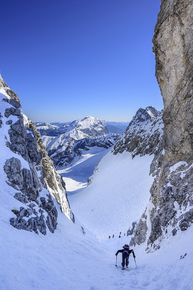 Several persons back-country skiing ascending through gully to Hochglueckkar, Hochglueckkar, Eng, Nature Park Karwendel, Karwendel range, Tyrol, Austria