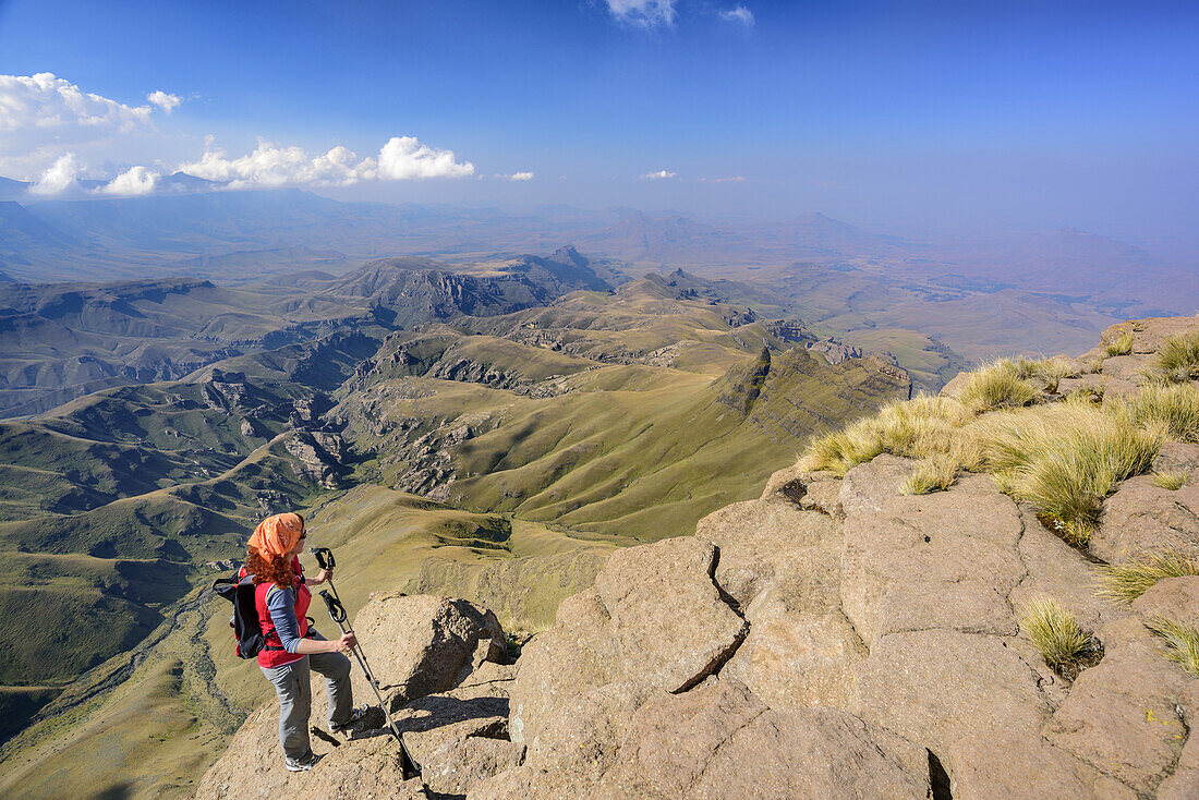 Frau beim Wandern steigt über Felsplatten zum Rhino Peak auf, Rhino Peak, Garden Castle, Mzimkhulu Wilderness Area, Drakensberge, uKhahlamba-Drakensberg Park, UNESCO Welterbe Maloti-Drakensberg-Park, KwaZulu-Natal, Südafrika