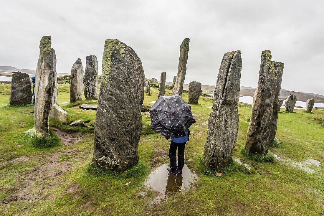 A photographer with the standing Stones of Callanish, Isle of Lewis, Scotland.