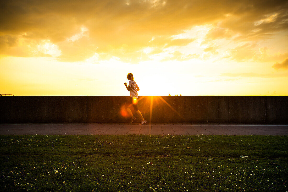 Healthy woman running at sunset.