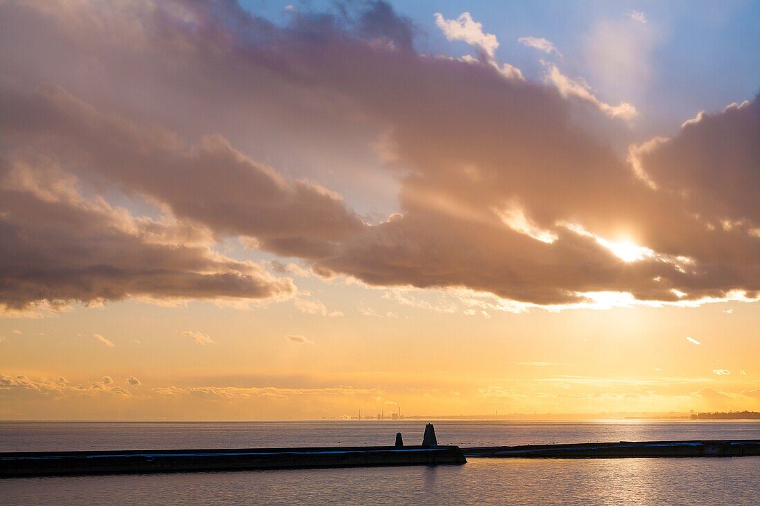 The setting sun over Lake Ontario at Marilyn Bell Park in Toronto, Ontario, Canada.