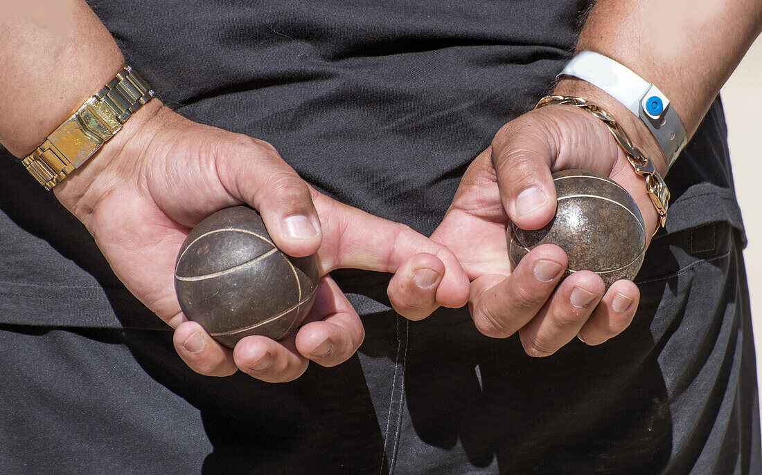 Two metal balls for game in pétanque in man´s hands.