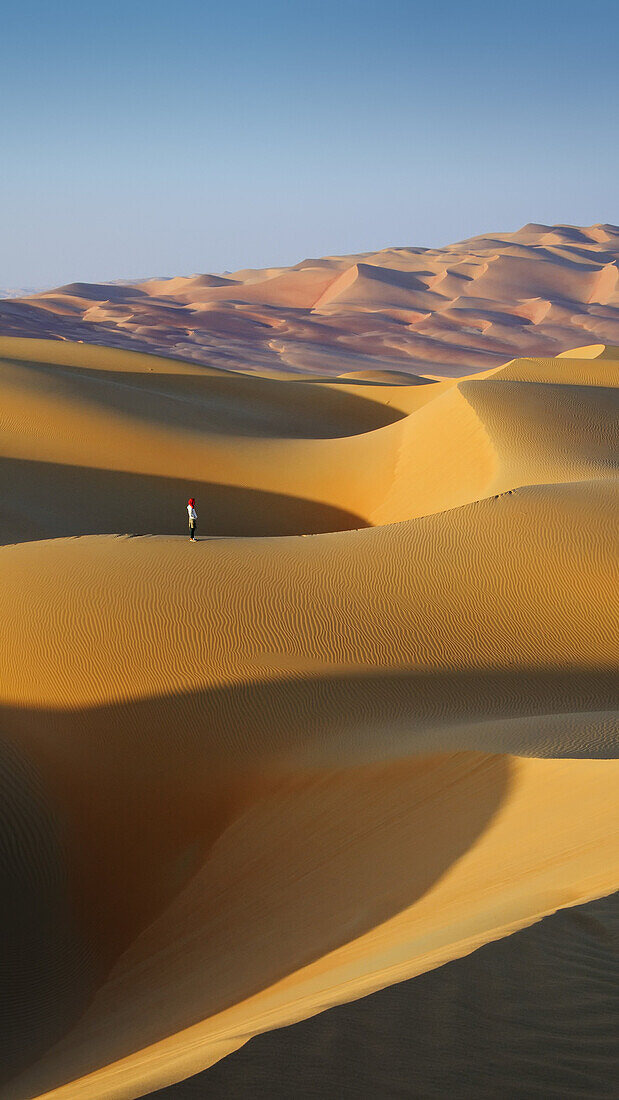 Woman in the sand dunes of the empty quarter desert. United Arab Emirates, UAE, Abu Dhabi, Liwa Oasis, Moreeb Hill, Tal Mireb. Model Released.
