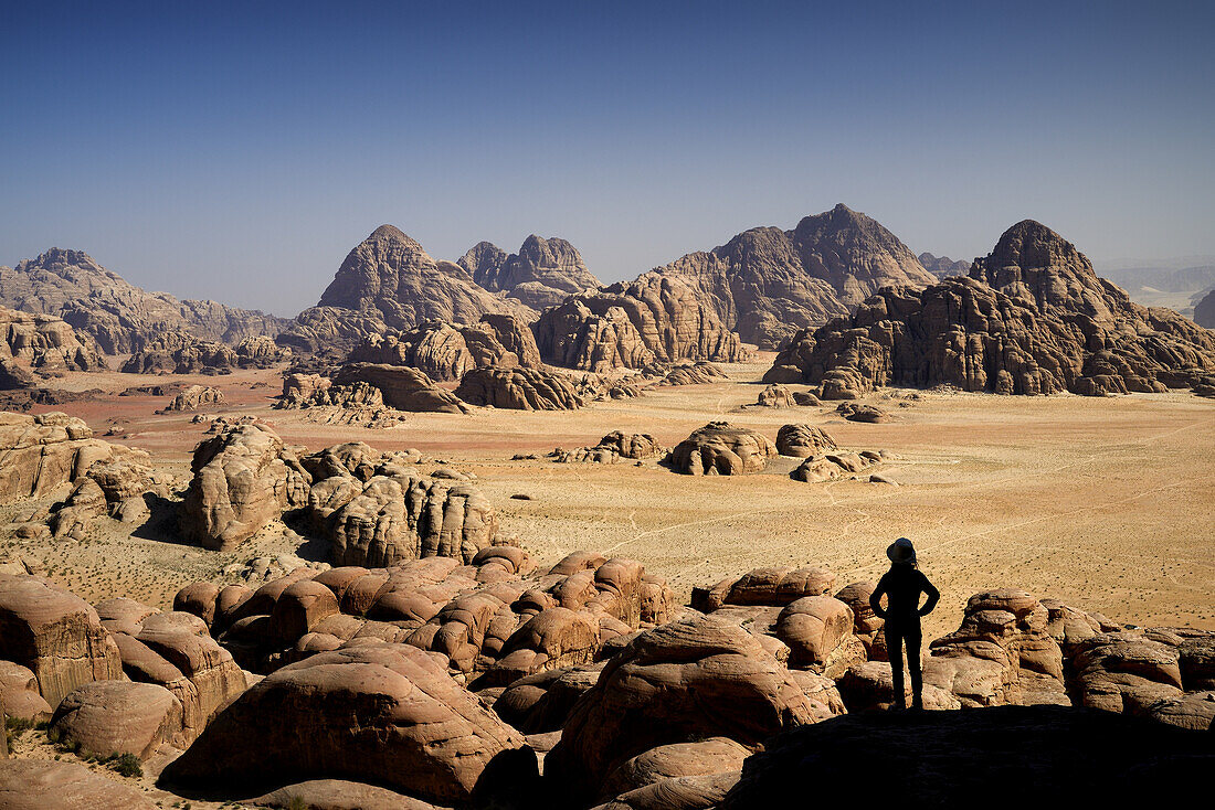 Silhouette of a woman contemplating the landscape from the mount Jebel Burdah. Jordan, Wadi Rum desert, protected area inscribed on UNESCO World Heritage list. Model Released.