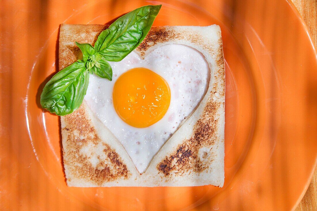 breakfast of toast and eggs in the shape of heart.