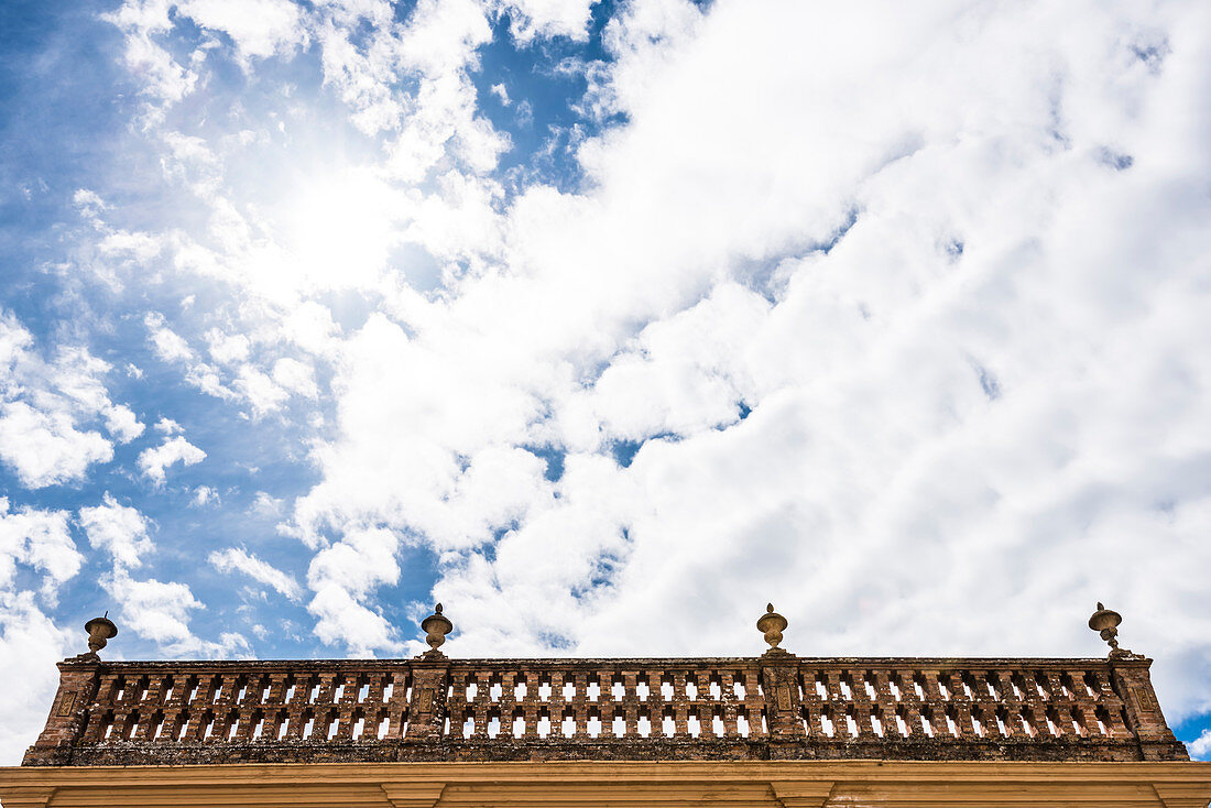 Ein Balkon mit Steingeländer und Steinvasen vor stimmungsvollem Himmel, Cortes de la Frontera, Andalusien, Spanien