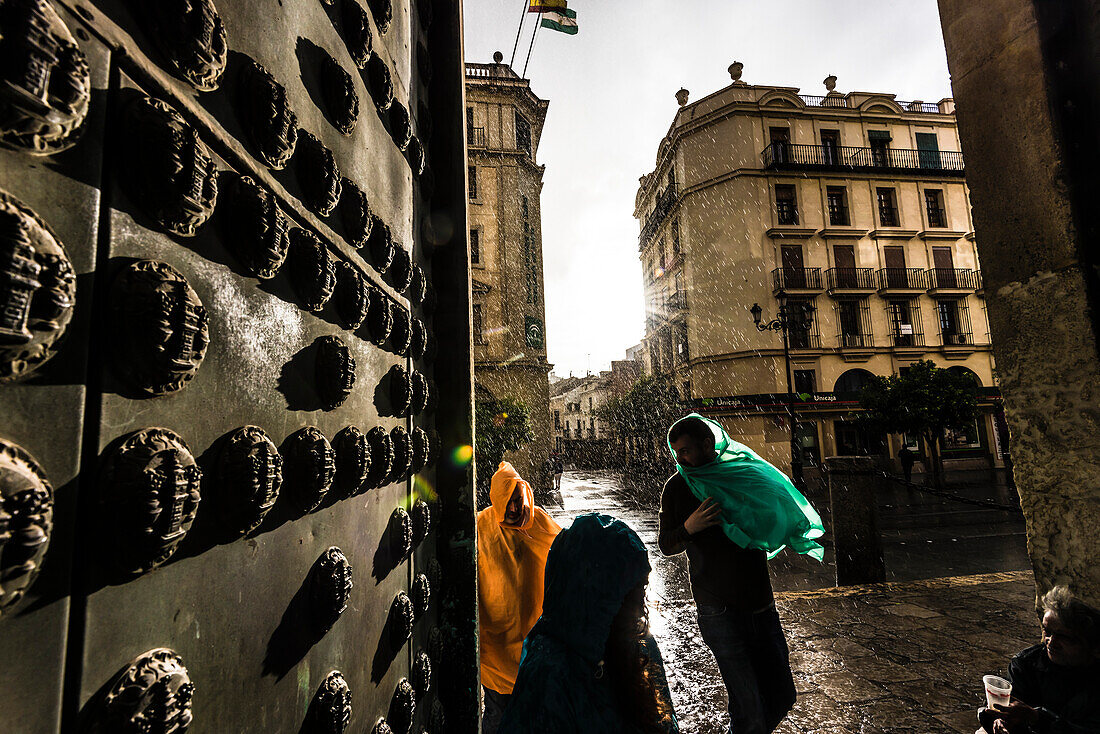 Touristen im Regen am Seiteneingang zur Kathedrale im historischen Zentrum, Sevilla, Andalusien, Provinz Sevilla, Spanien