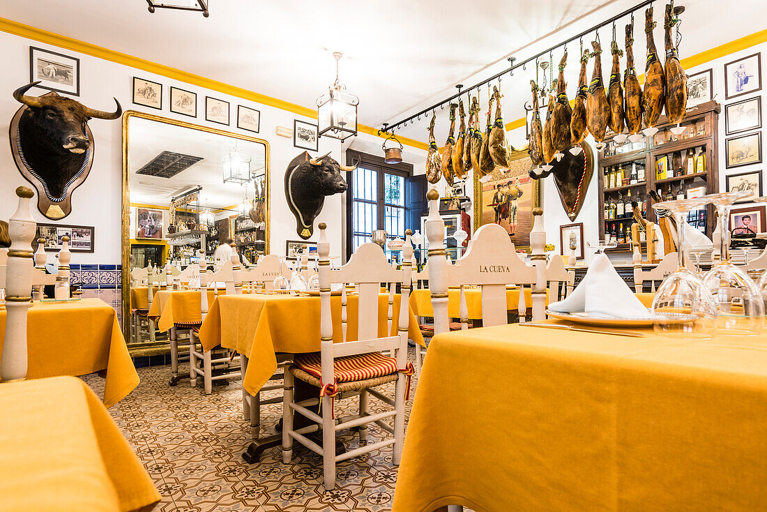 A typical traditional restaurant with ham and decorations in the historical centre, Seville, Andalusia, province Seville, Spain