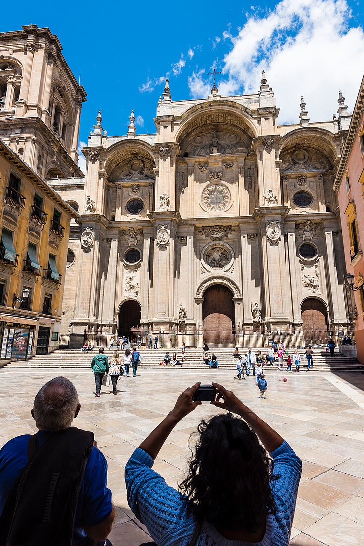 Tourists taking photos of the cathedral on Plaza de las Pasiegas square, Granada, Andalusia, Spain