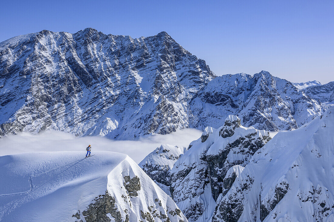 Person back-country skiing ascending to snow-summit in front of Watzmann, Hochalm, Hochkalter, National Park Berchtesgaden, Berchtesgaden Alps, Berchtesgaden, Upper Bavaria, Bavaria, Germany