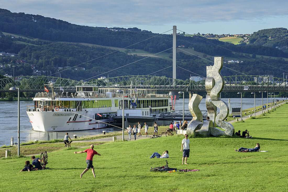 Recreation area at Danube with modern sculpture and Danube with ship in background, Linz, Danube Bike Trail, Upper Austria, Austria