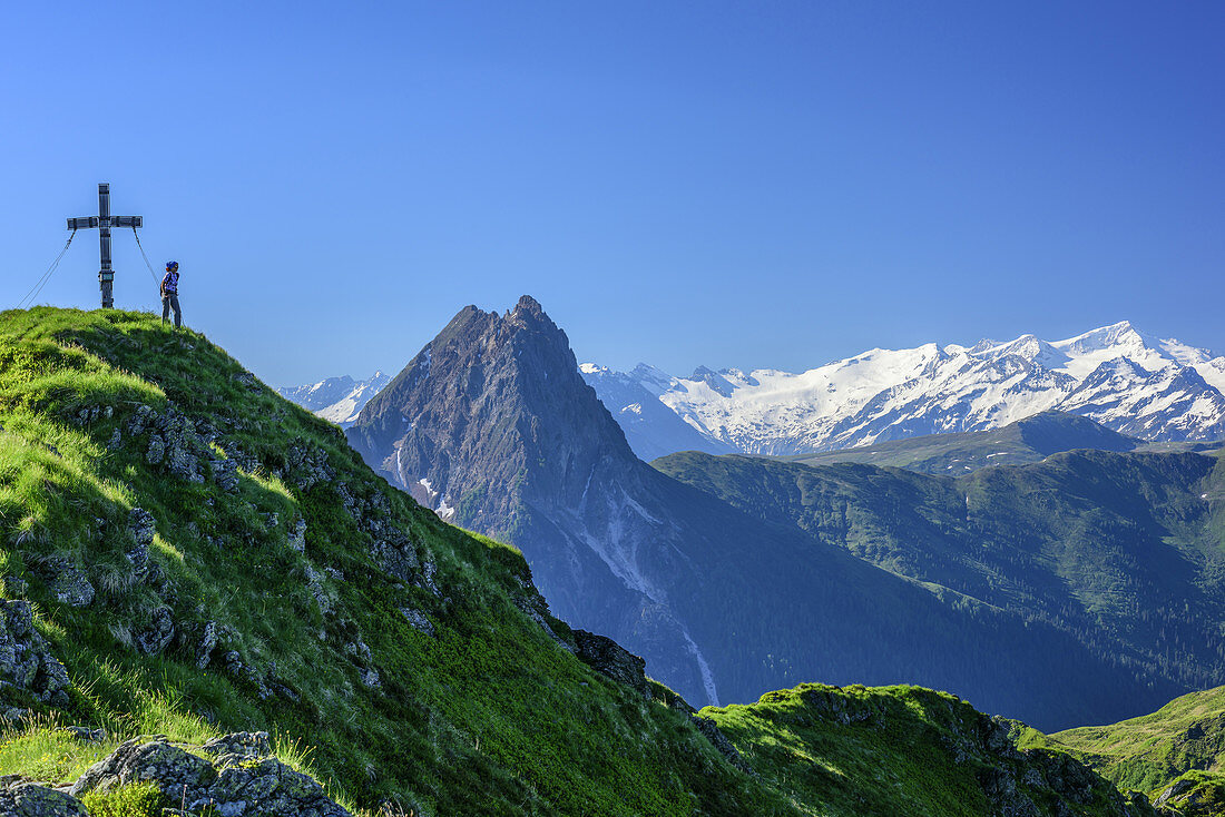 Frau steht am Gipfel des Brechhorn, Großer Rettenstein mit Großvenediger im Hintergrund, Brechhorn, Kitzbüheler Alpen, Tirol, Österreich