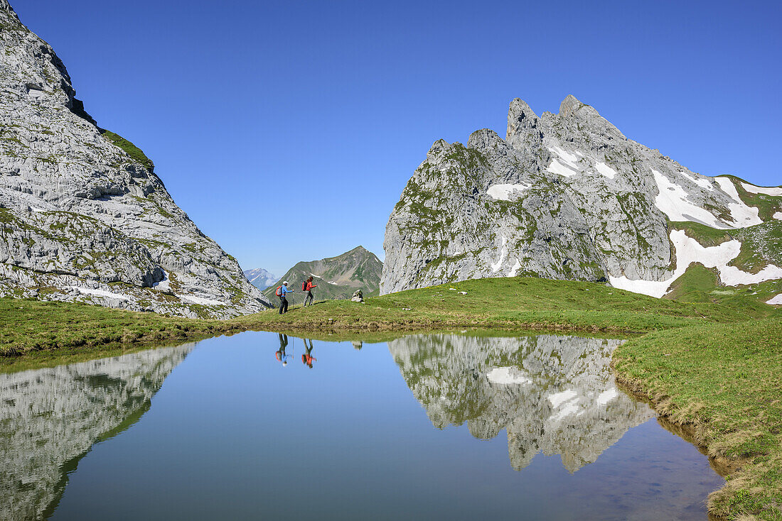 Two persons hiking at mountain lake, Schweizer Tor, Raetikon trail, Raetikon, Vorarlberg, Austria