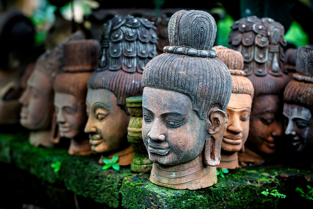 'Heads of statues of Buddha are stacked in a terra-cotta factory; Chiang Mai, Thailand'