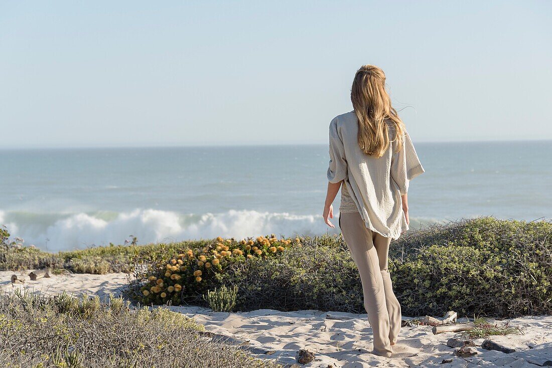 Rear view of a woman standing on the beach