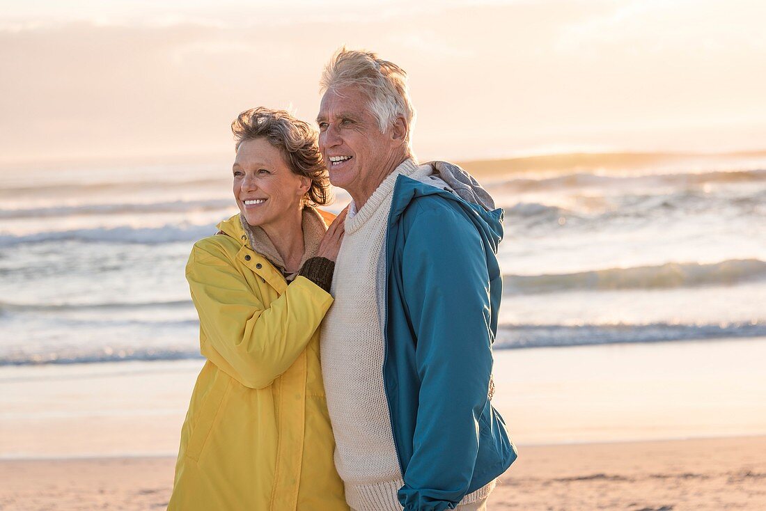 Happy senior couple standing on the beach