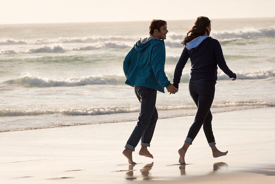 Happy young couple running on beach