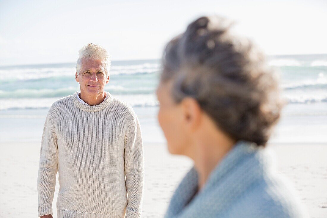 Senior man looking at his wife on the beach