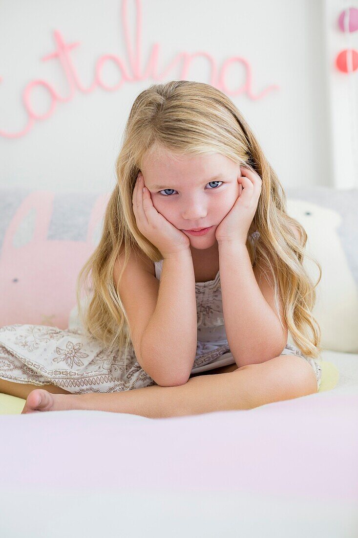 Portrait of a cute girl sitting on bed