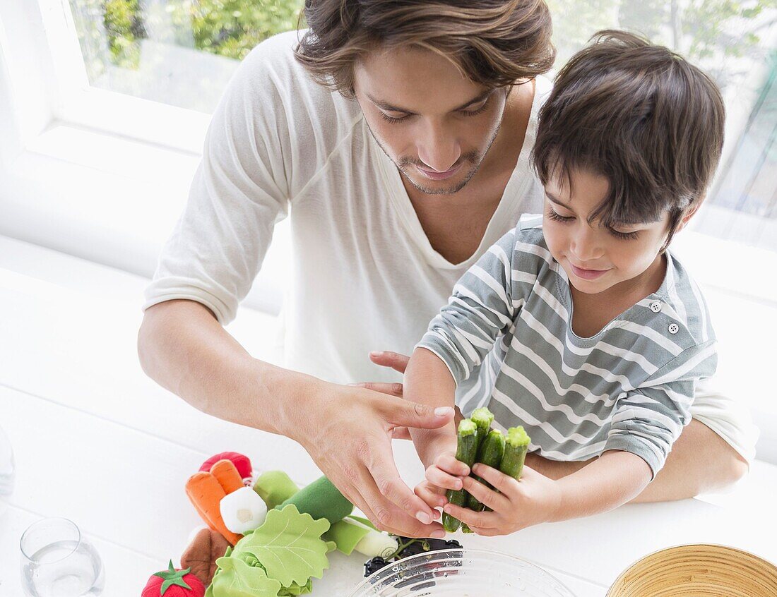 Happy young family preparing vegetables at home