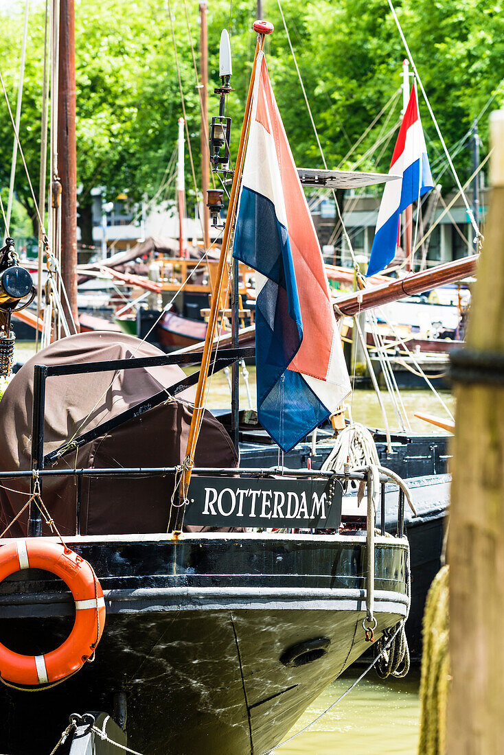 Boats in the harbour of Haringvliet with Rotterdam caption and national flag, Rotterdam, the Netherlands