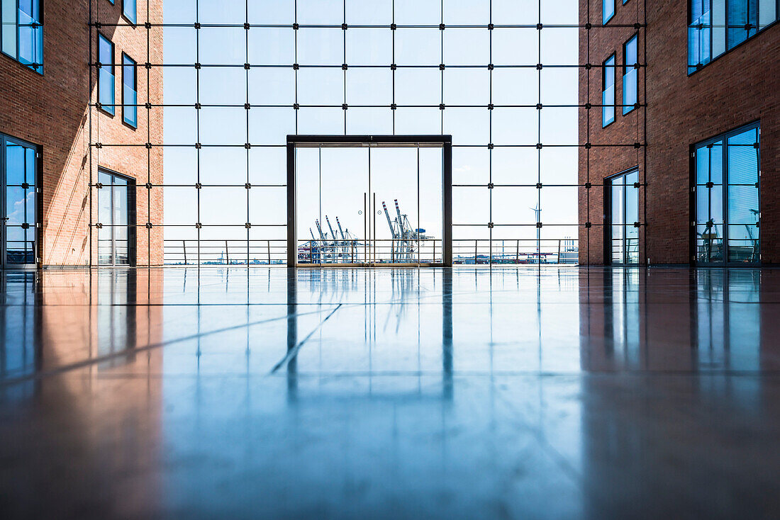 The inner courtyard of the office house Elbflorenz in Grosse Elbstrasse in the old timber harbour with view to container cranes, Hamburg, Germany