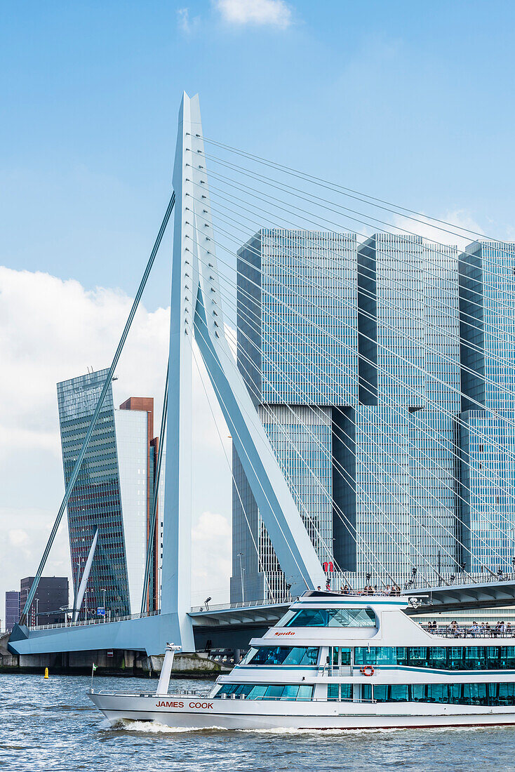 An excursion boat on the river Maas passing the Erasmus bridge with view at the high rise building ''De Rotterdam'' on the south shore, Rotterdam, Netherlands