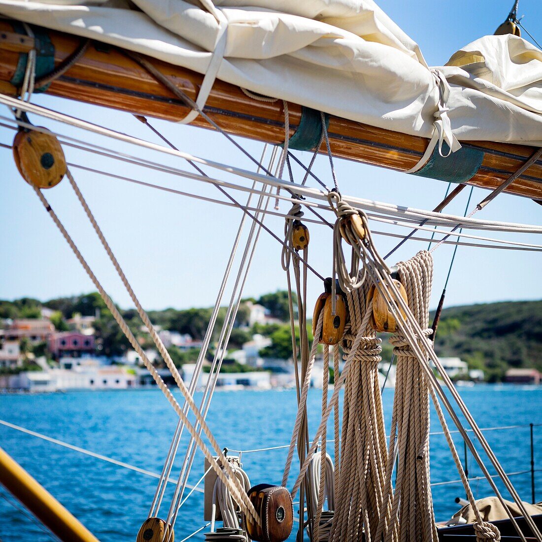 Close up of masts and rigging from a vintage boat, with a blue sky in the background. pulleys, sails and ropes. Port Mahon, Menorca, Biosphera Reserve, Balearic Islands, Spain, Europe.