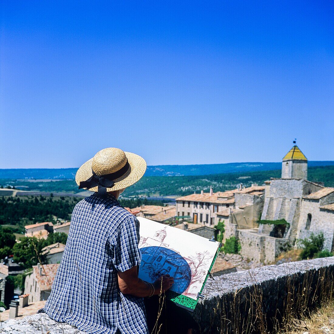 Middle aged woman drawing Aurel perched village, Vaucluse, Provence, France.