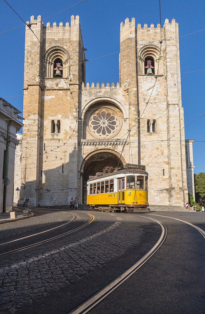 The yellow tram number 28 close to the ancient Cathedral (Se), Alfama district, Lisbon, Portugal, Europe