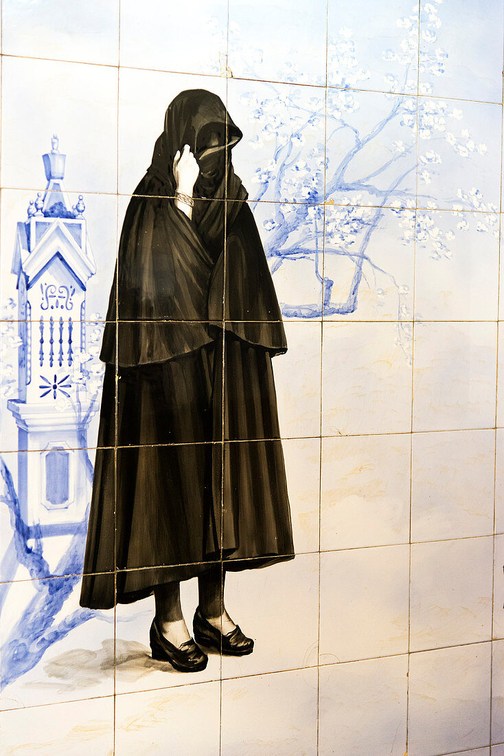 Azulejos representing a Portuguese woman wearing a dark cape, Olhao, Algarve, Portugal, Europe