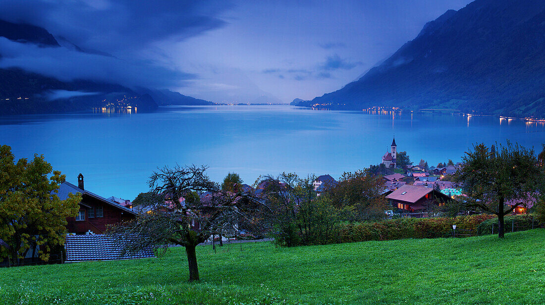 Looking over the chalets and church of Brienz to Lake Brienz as twilight falls over the Bernese Oberland, Switzerland, Europe