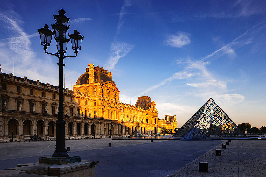 Dawn light illuminates the Louvre Palace bordering the Napoleon Courtyard and Louvre Pyramid, Paris, France, Europe