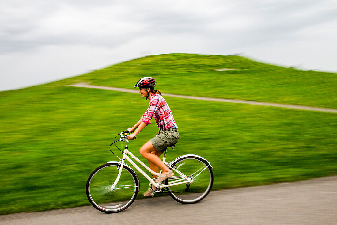 A woman rides her cruiser bike at Gasworks Park in Seattle, Washington on a cloudy day