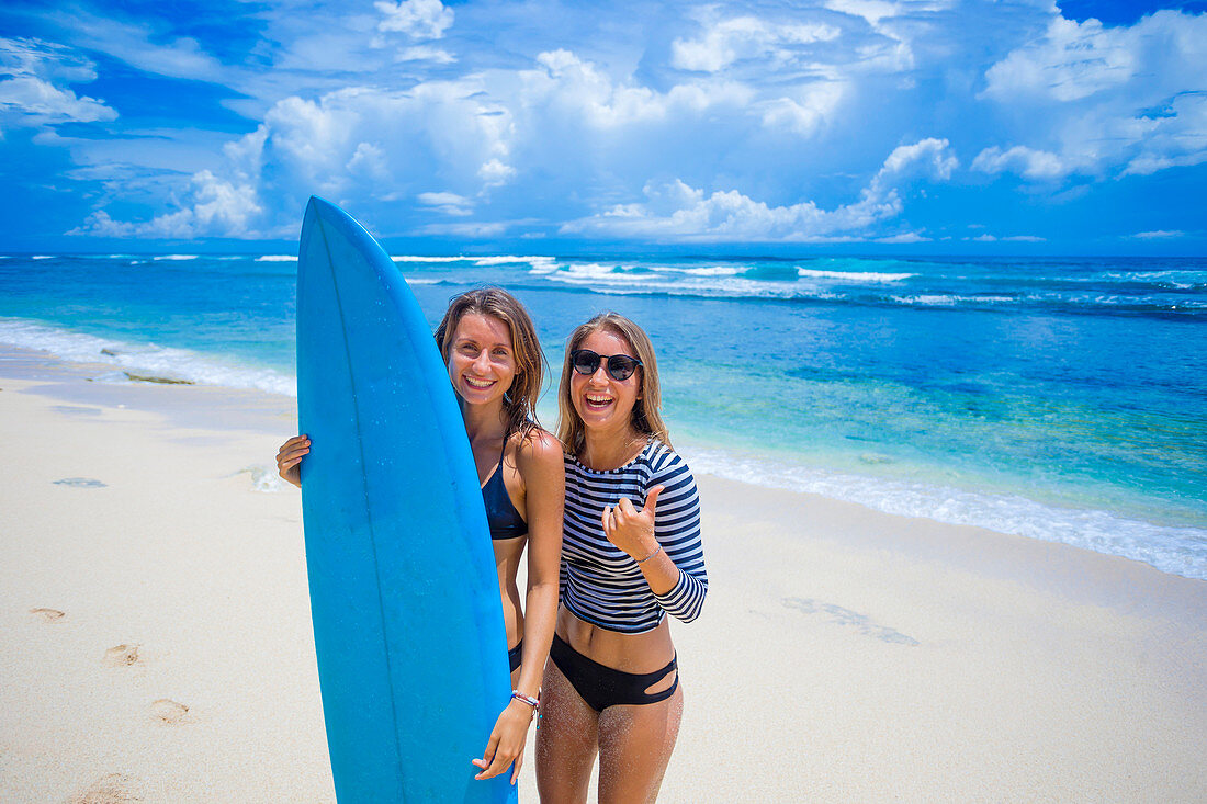 Couple of happy girls with surfboard