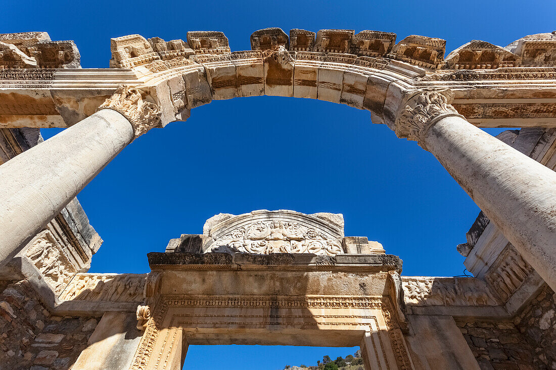 'Low angle view of an arch in ancient ruins against a blue sky; Ephesus, Turkey'