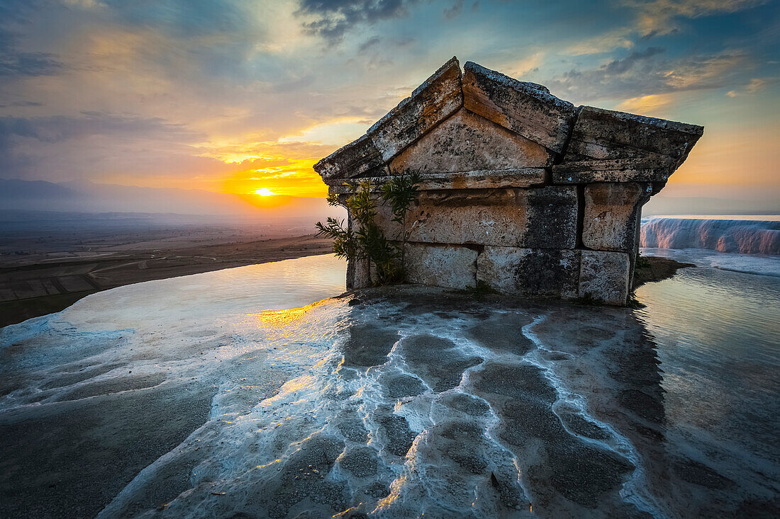 'Tomb submerged in a travertine pool in Hierapolis at sunset; Pamukkale, Turkey'