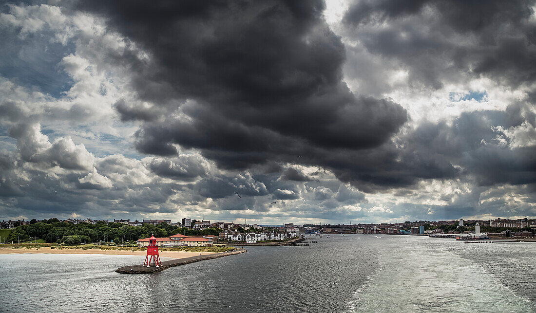'Red Herd Groyne lighthouse at the end of a pier under storm clouds; South Shields, Tyne and Wear, England'