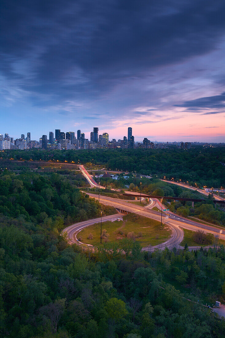 'Sunset looking south over the Don Valley, Bloor on-ramp, Toronto skyline and Don Valley Parkway; Toronto, Ontario, Canada'