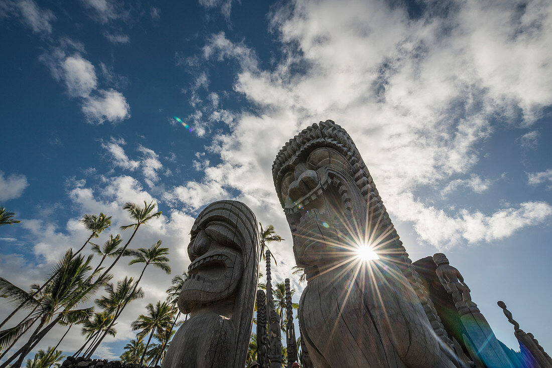 'Afternoon sun shines through statues at Puuhonua O Honaunau National Historic Park; Island of Hawaii, Hawaii, United States of America'