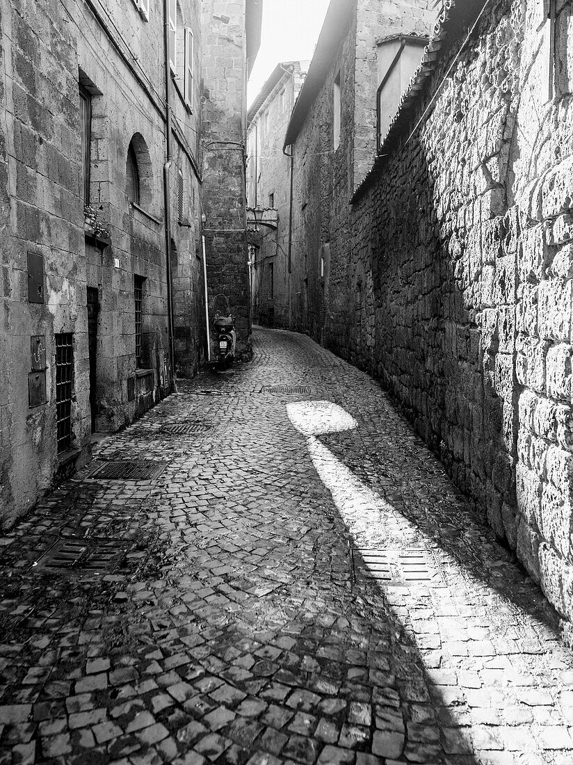 'Narrow cobblestone alley between buildings; Orvieto, Umbria, Italy'