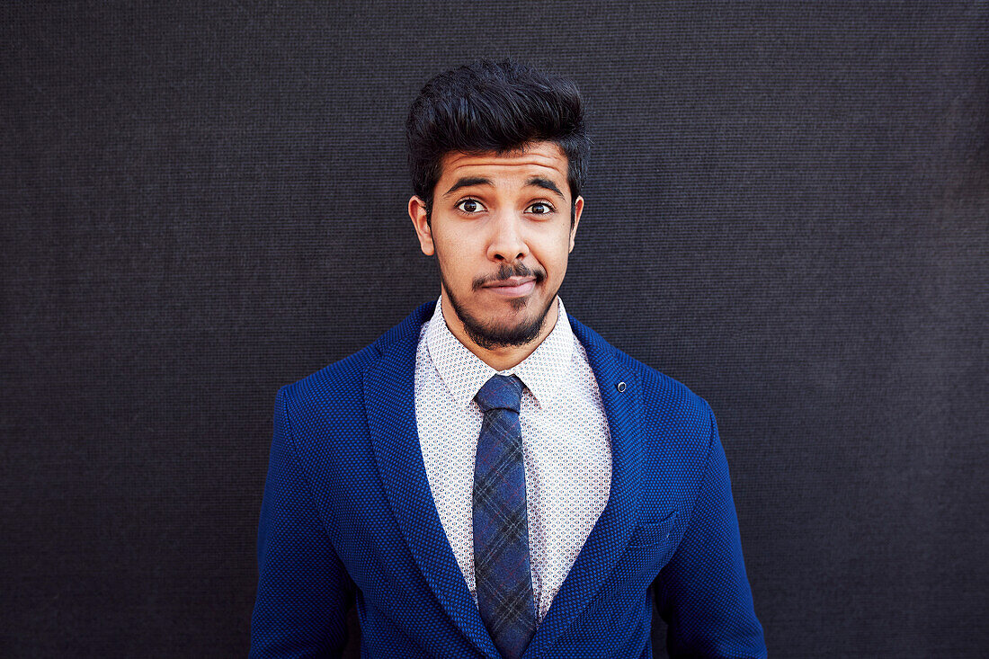 Uncertain Middle Eastern man wearing jacket and tie