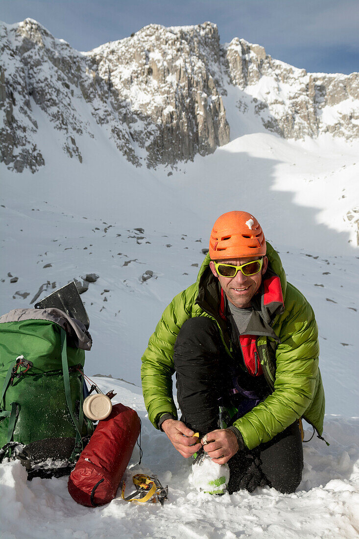 A man camping below Thunderbolt Ridge, Hogum Fork on a backcountry ski tour in Little Cottonwood Canyon, Lone Peak Wilderness, Uinta-Wasatch-Cache National Forest, Salt Lake City, Utah.