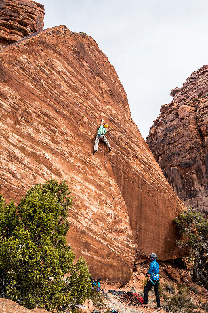 A man and woman rock climbing on the Hamm Boulder in Big Gypsum Valley, Naturita, Colorado