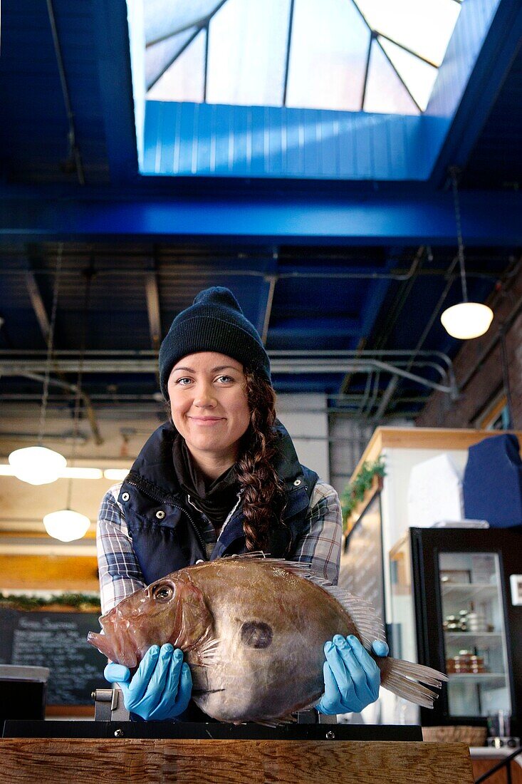 Portrait of woman holding fish in fish store