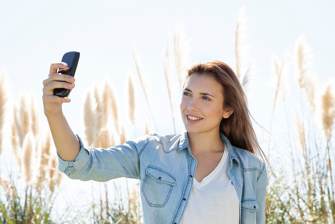 Frau posiert für ein Selfie im Freien