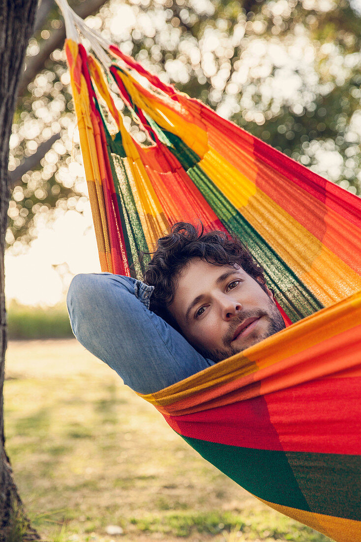 Man relaxing in hammock, portrait