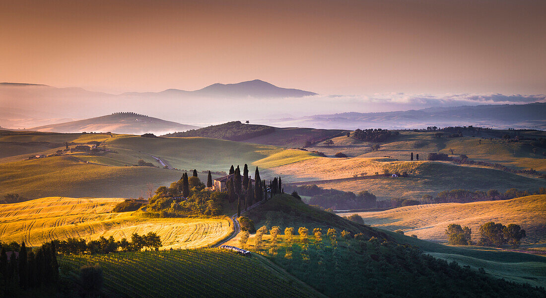 Podere Belvedere, San Quirico d'Orcia, Tuscany, Italy. Sunrise over the farmhouse and the hills.