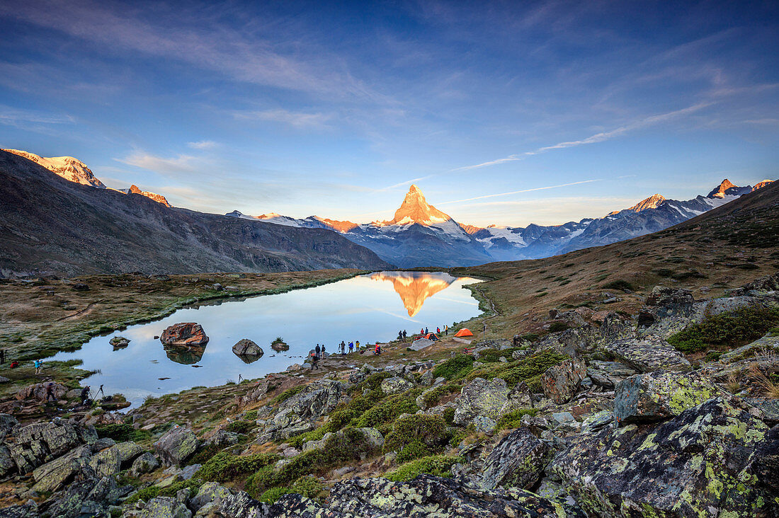 Hikers admire Matterhorn reflected in Lake Stellisee at dawn Zermatt Canton of Valais Switzerland Europe